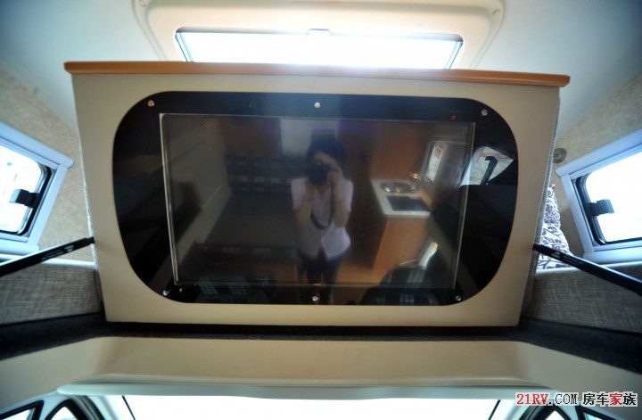 驾驶室上方设有一台固定的液晶电视，驻车时丰富了车内的娱乐生活，音响分布在车内四周.jpg